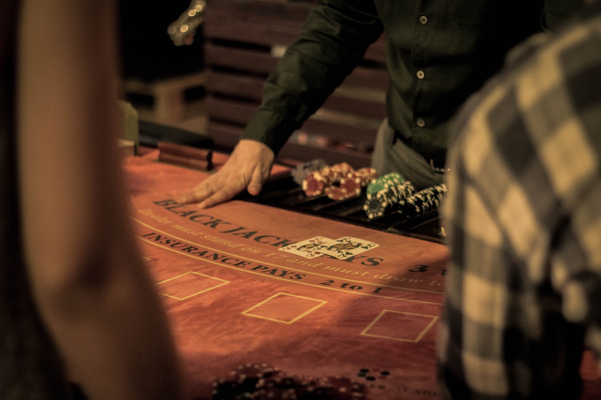 Live blackjack dealer pushing chips across the felt